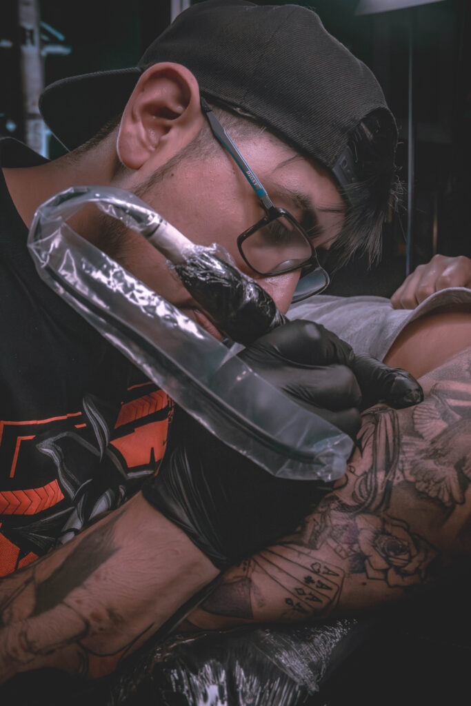 Tattoo artist working on a tattoo in a studio